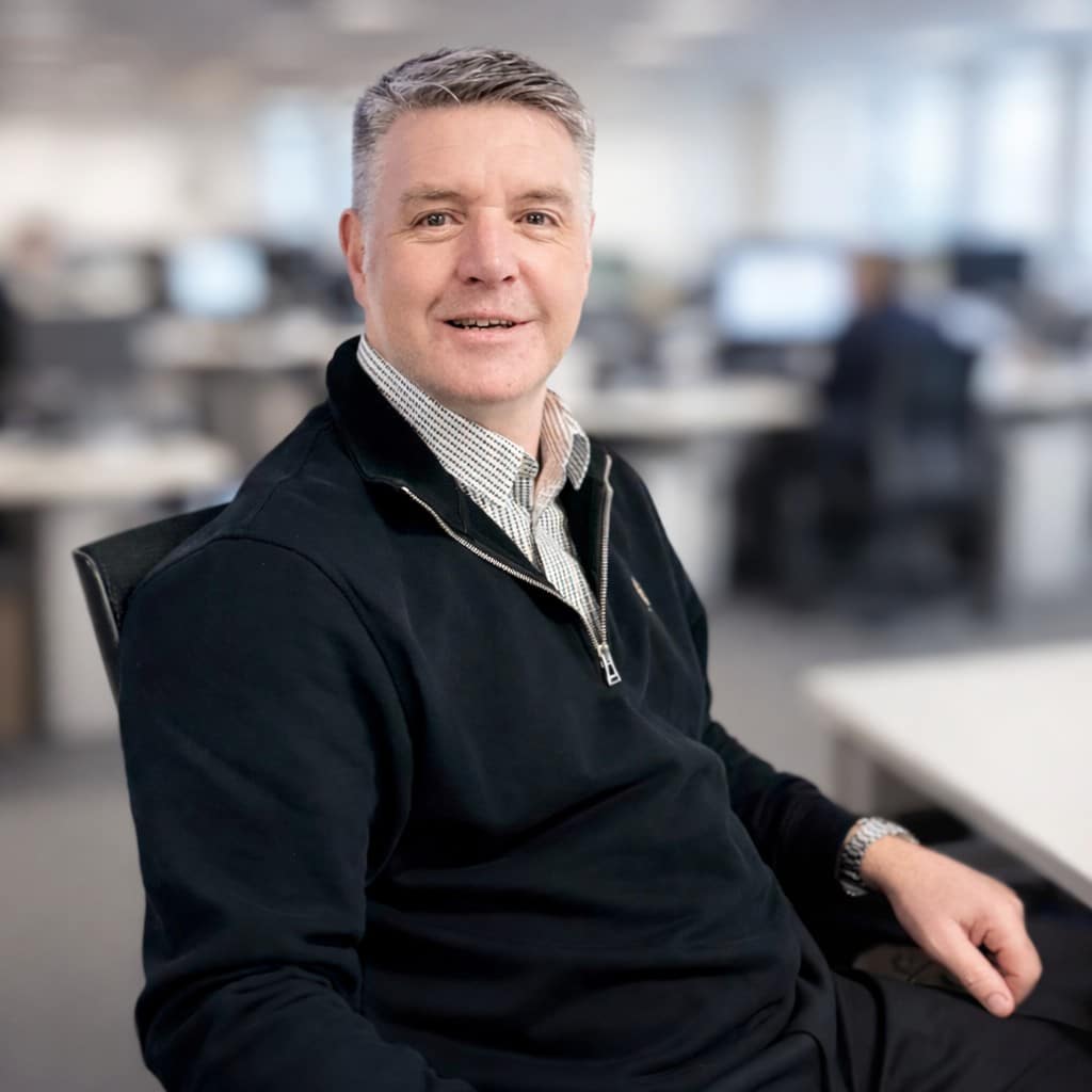 man sat on chair smiling