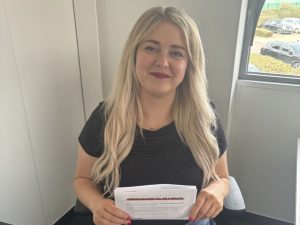 photo of young lady in office holding up letter